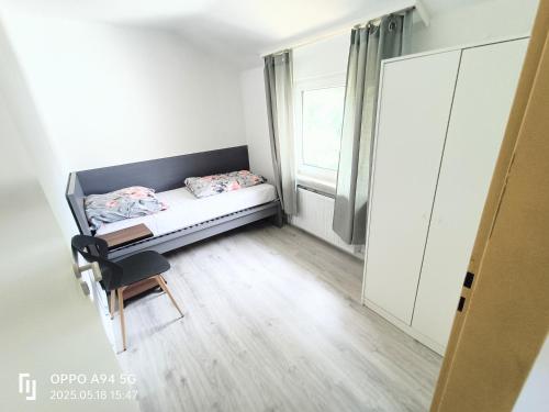 a small bedroom with a bed and a chair at FMi21 in Hochheim am Main