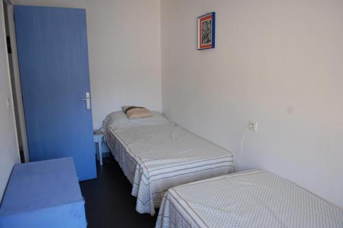 ロザスにあるGlobal Immo 4063 Xavi IIのベッド2台と青いドアが備わる客室です。