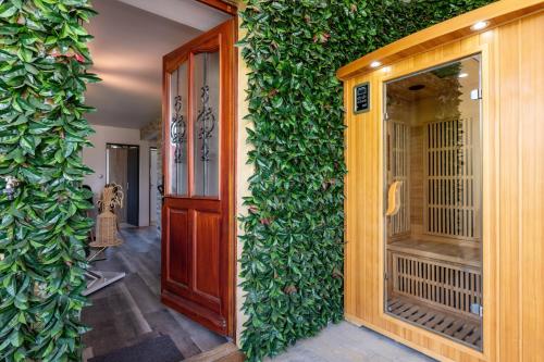 un mur recouvert de lierre vert à côté d'une porte dans l'établissement Appartement T3 portes d'Annecy Sauna, à Annecy