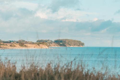 a large body of water with an island in the distance at TiBu - Mietwohnwagen Fehmarn in Fehmarn