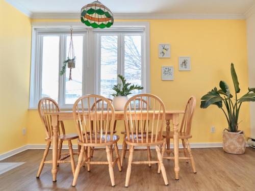 a dining room with a wooden table and chairs at BALCON BLANC - Auberge à Chicoutimi, Saguenay in Saguenay