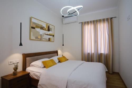 a bedroom with a white bed and a fan at Iris Luxury Loft in Mytilini