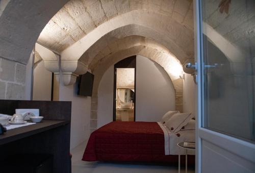 a bedroom with a red bed in a room at ENOTRIO caveoso in Matera
