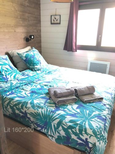 une chambre avec un lit avec des serviettes dessus dans l'établissement L'échassier, à Grandcamp-Maisy