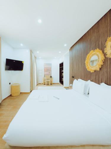 a bedroom with a large bed and a tv at Medina Hotel Dakhla in Dakhla
