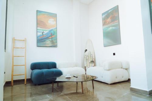 a living room with a couch and a table and a surfboard at Medina Hotel Dakhla in Dakhla