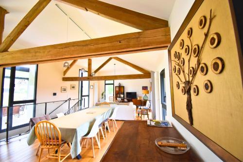 une salle à manger et un salon avec une table et des chaises dans l'établissement La Grange au Fil du Parc, à Ermenonville
