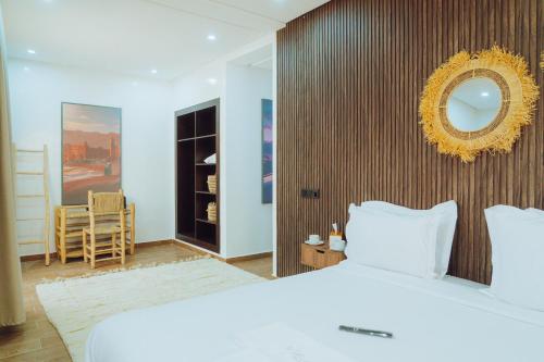 a bedroom with a white bed and a mirror at Medina Hotel Dakhla in Dakhla