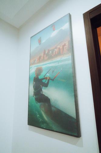 a painting of a man holding a kite on a wall at Medina Hotel Dakhla in Dakhla