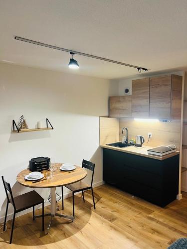 une cuisine avec une table et des chaises dans une pièce dans l'établissement Charmant logement tout confort, à Bernex