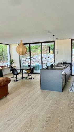 Il comprend un grand salon avec une cuisine et une table. dans l'établissement Côté pinède, à Prades-le-Lez