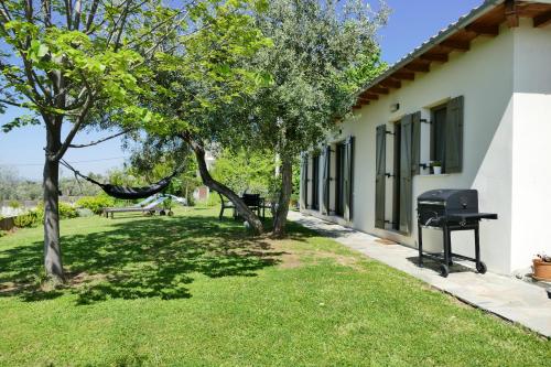 a house with a hammock and trees in the yard at Art Villa Pelion in Agria
