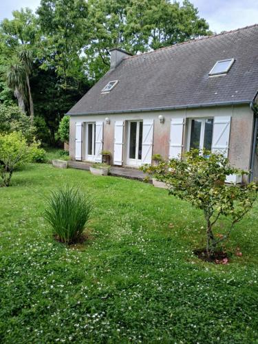 une petite maison blanche avec un arbre dans la cour dans l'établissement Maison indépendante agréable et ensoleillée, à La Celle-sous-Gouzon