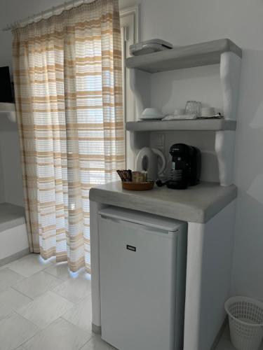 a kitchen with a counter and a small refrigerator at Captain Stavros in Pollonia