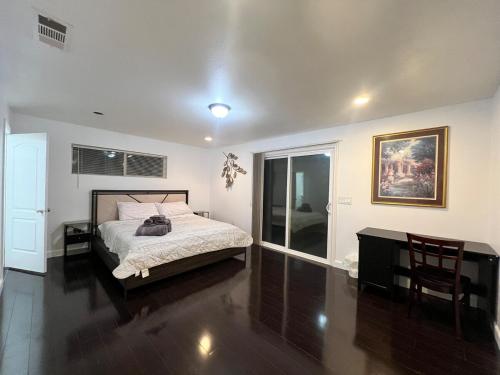 a bedroom with a bed and a table and a window at Near Disney,college,sunset beach ,airport in Norwalk