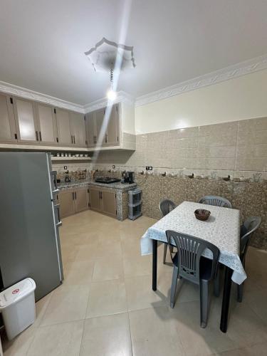 a large kitchen with a table and chairs in a room at Appartement moderne à Benguérir in Benguerir