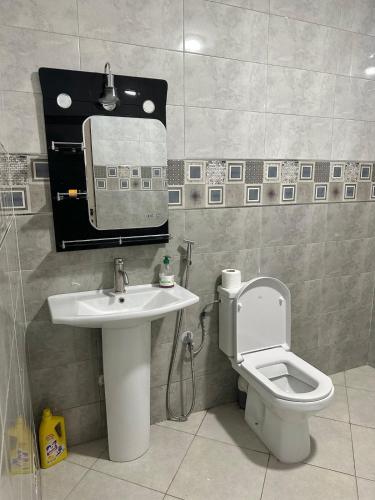 a bathroom with a sink and a toilet and a mirror at Appartement moderne à Benguérir in Benguerir