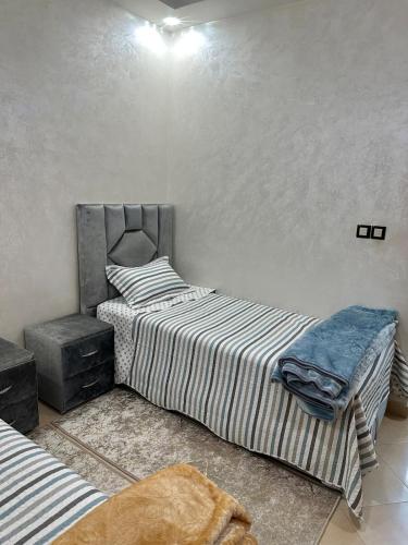 two twin beds in a room with at Appartement moderne à Benguérir in Benguerir