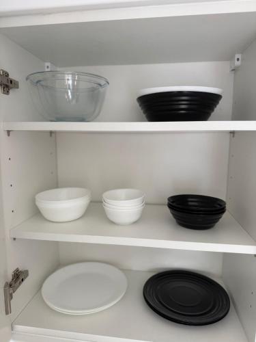 a white shelf with bowls and plates on it at Modern Family 3 bedroom house,Free Parking,Garden in Dagenham