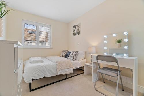 a bedroom with a bed and a desk and a chair at 3 Bed - Sleeps 7 - Hot-Tub - Free Parking in Hornchurch