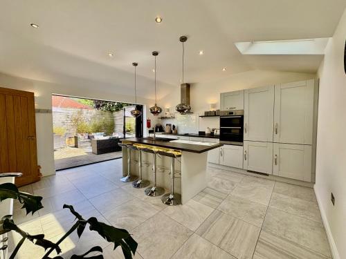 a kitchen with white cabinets and a large island at Eden Cottage in Frodsham