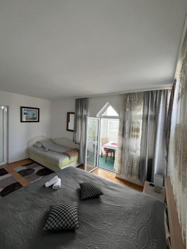 a bedroom with a bed and a sliding glass door at Prenoćište Delija 020 in Sjenica