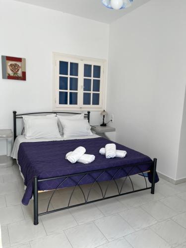 a bedroom with a bed with two towels on it at Captain Stavros in Pollonia