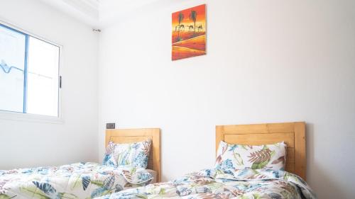 two beds sitting next to each other in a bedroom at Happy Waves Morocco in Taghazout