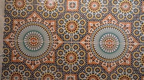a close up of a tile floor with patterns on it at Happy Waves Morocco in Taghazout