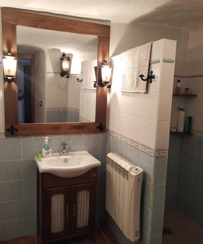 a bathroom with a sink and a mirror and a radiator at Casa Cueva, Cuevas del Emir in Freila