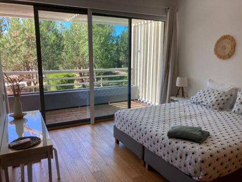 a bedroom with a bed and a view of a balcony at Casa Do Mar - Sea View Beach House - Troia Comporta in Troia