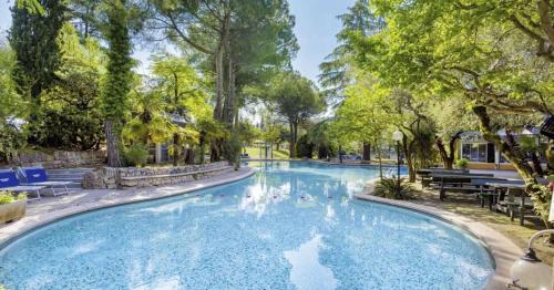 a swimming pool in a park with trees at Casa Alice Garda in Garda