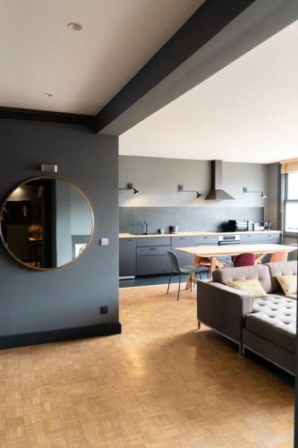 un salon avec un canapé et un miroir dans l'établissement Amazing appartements on Champs-Elysées, à Paris