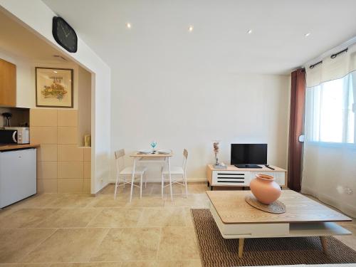 un salon avec une table et une cuisine dans l'établissement Calm and central studio, à Cannes