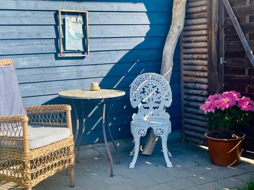 a blue house with a chair and a table at Rørvig Bed & Kitchen in Rørvig