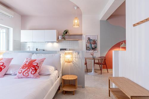 a living room with a white couch and a table at Marenia Holiday Apartments and Rooms - mare e relax - in Lido di Latina 