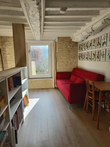 - un salon avec un canapé rouge et une fenêtre dans l'établissement LE SEIZE - Gîte 4 personnes - entre Caen et la mer, à Cairon