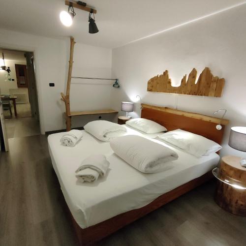 a bedroom with a bed with white sheets and pillows at La Bouganville in Arco