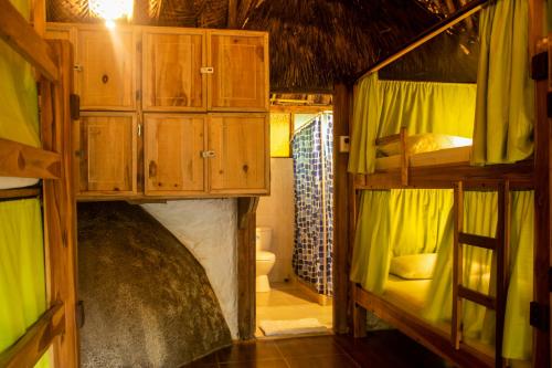 a room with bunk beds and a bathroom with a toilet at Eco Hostal Yuluka in El Zaino