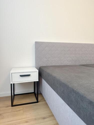 コシツェにあるYour home 17 with parkingの白いナイトスタンドが横に置かれたベッド