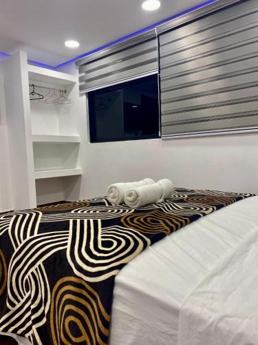 a bedroom with a bed with a blanket and a window at Posada Restaurant La Guaricha in Catia La Mar