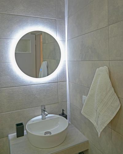 a bathroom with a sink and a mirror at Ellovos, View from Above in Samos