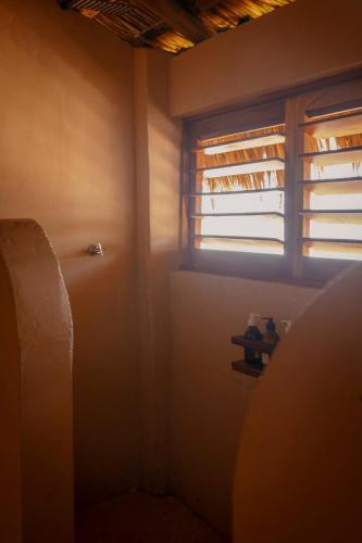 a small room with a window and a refrigerator at Sebastian de los milagros in Zipolite