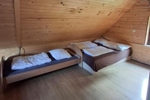 zwei Betten in einem Zimmer mit Holzwänden in der Unterkunft Chata Tatranský Kľud in Važec