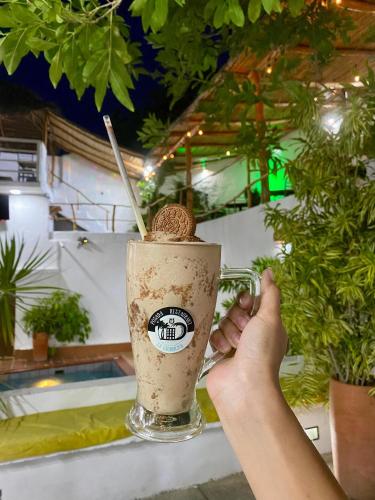 a person holding a cup of coffee on a table at Posada Restaurant La Guaricha in Catia La Mar