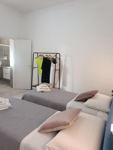 a bedroom with two beds and a room with a closet at Clio's House - Mondello in Mondello