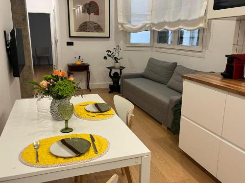 a kitchen and living room with a white table with yellow place settings at Bilbao City Center in Bilbao