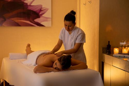 a woman getting a massage on a bed with a therapist at Casa Andina Select Tacna in Tacna