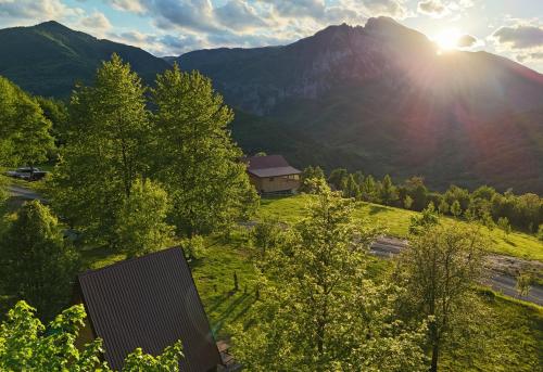 耶蒂斯特Tjentiste A-frame cabin的田野中的一栋房子，背景是群山