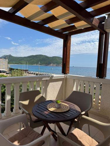 a table on a balcony with a view of the ocean at Apartments Villa Marija in Petrovac na Moru